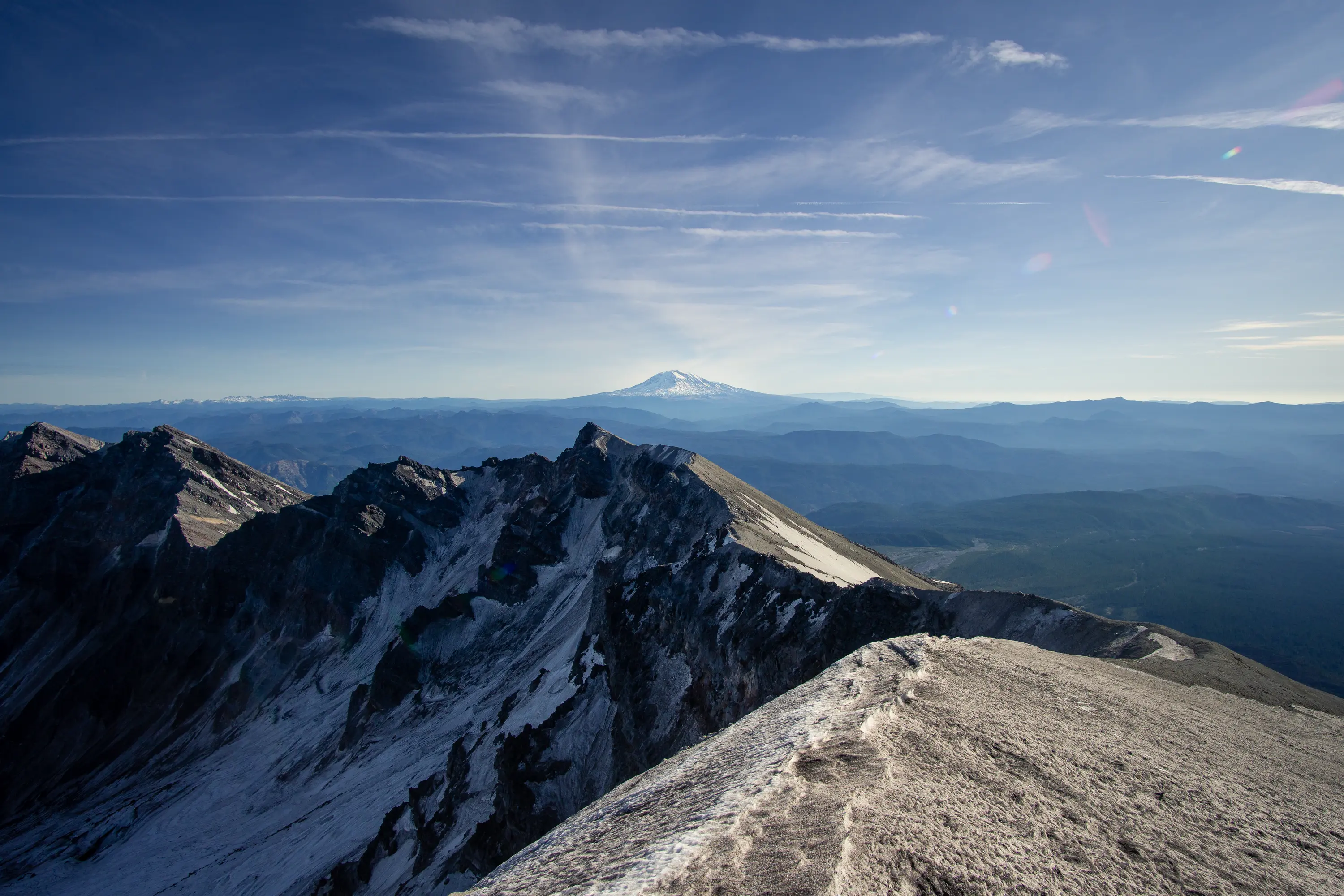 Mt. Adams in the distance, viewed through a missing chunk of Mt. St. Helens on a clear fall day.