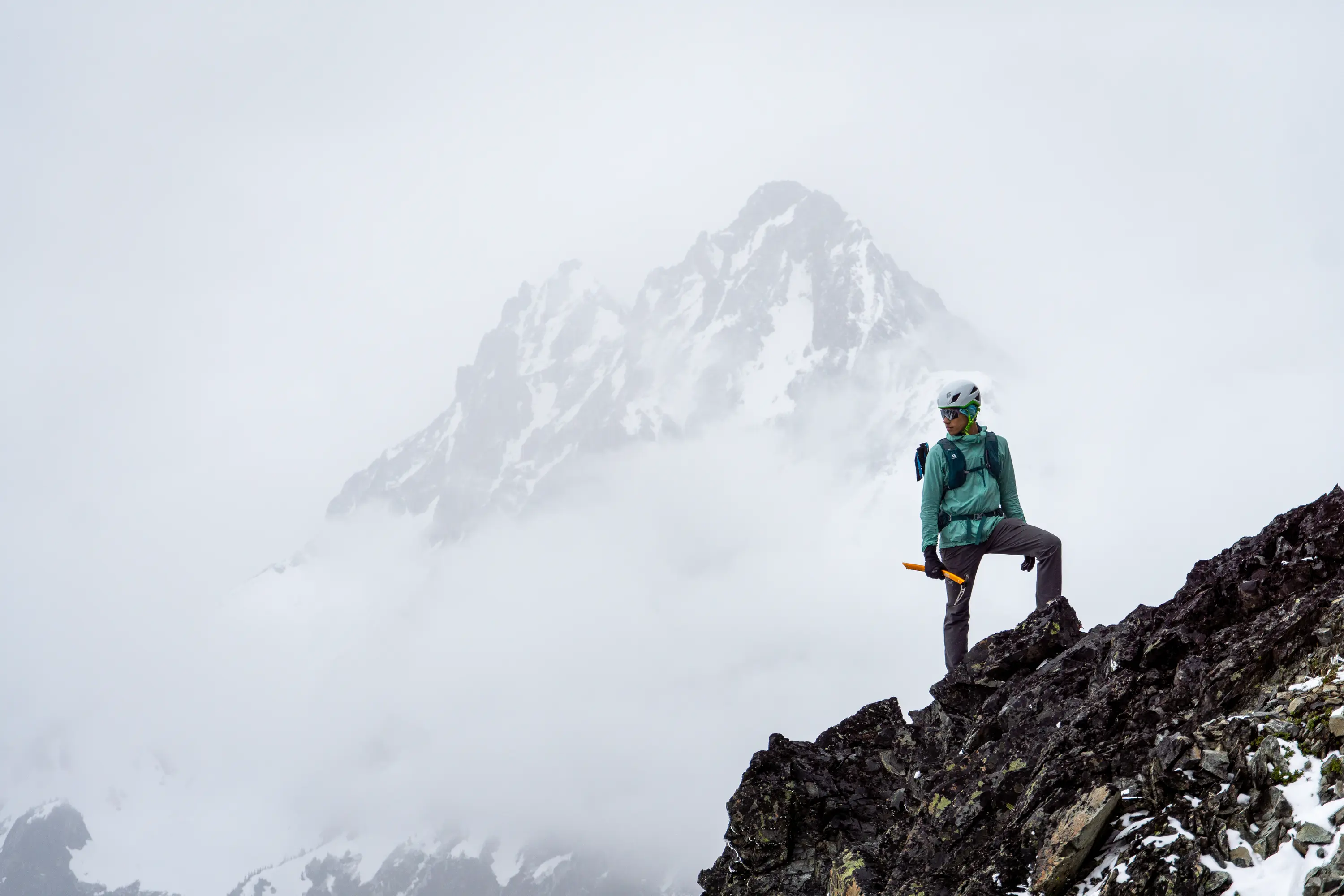 A friend of mine poses in front of Mesahchie Peak in the North Cascades during our ascent of Greybeard Peak.