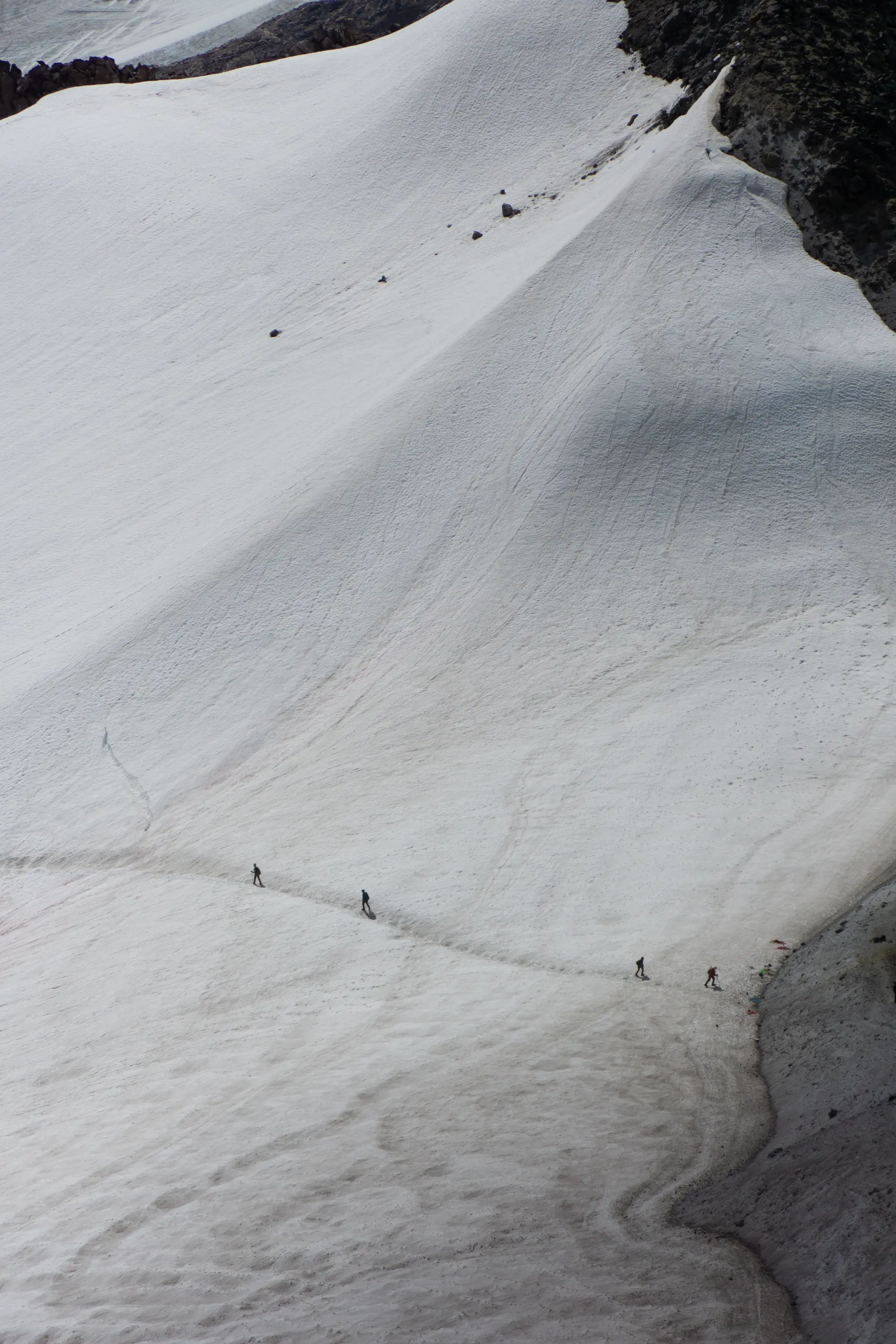 One party leaves and another party arrives at the upper reaches of the Cool Glacier on Glacier Peak.