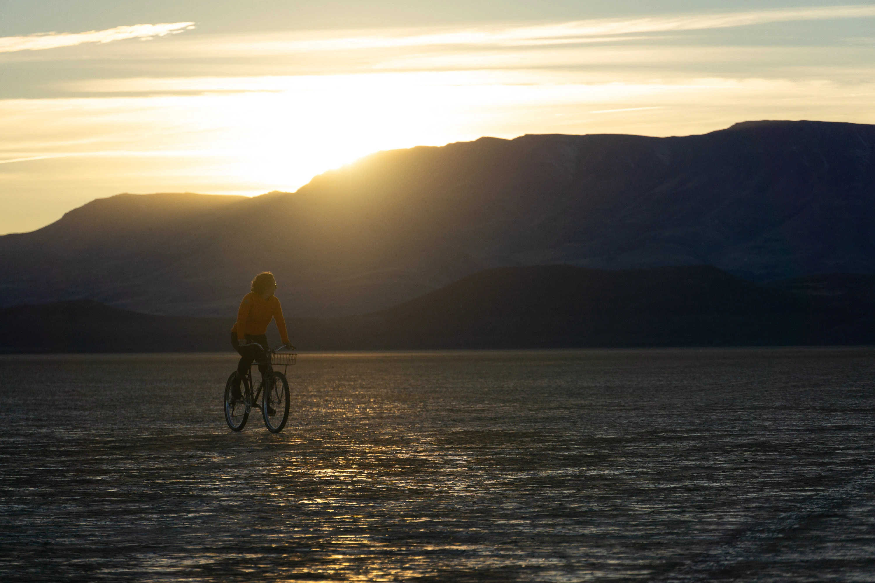A friend rides a bicycle through the Alvord desert, Oregon.